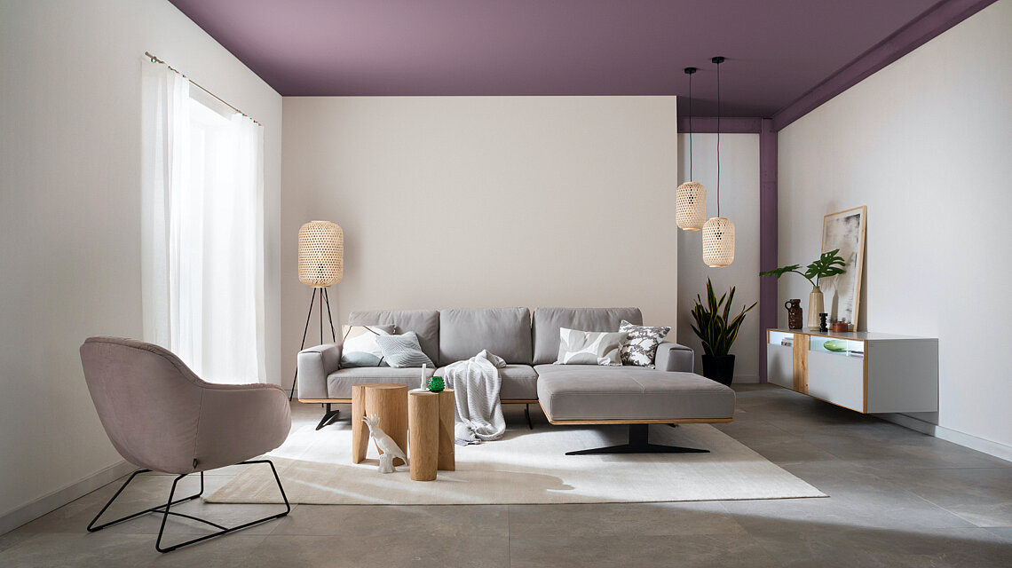 Schönes Wohnzimmer mit farbiger Decke in der SCHÖNER-WOHNEN-Designfarbe "Stilvolles Opalviolett"